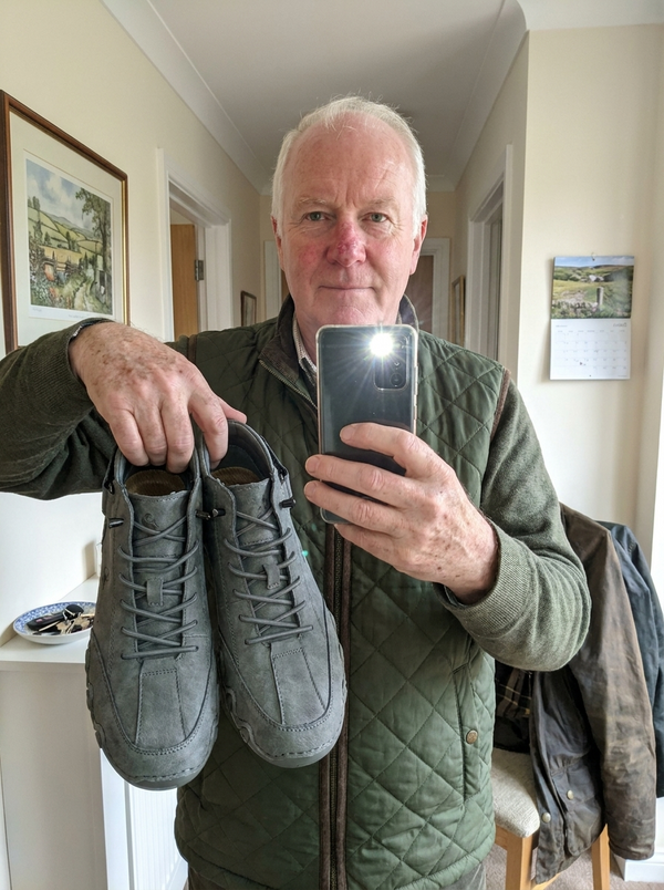 Customer photo — hallway mirror selfie holding the FeetFlex pair